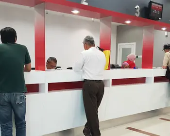 Kunden stehen an einem Schalter einer Bankfiliale